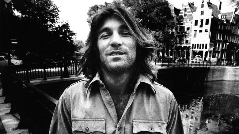 Dennis Wilson posing in front of a bridge