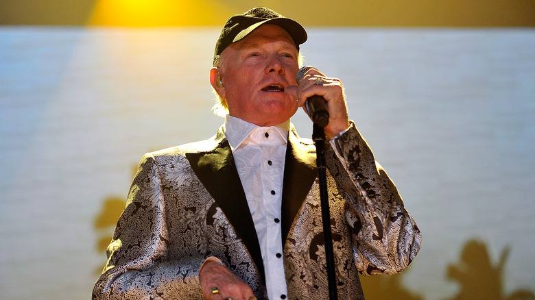 Mike Love singing live on stage into a microphone