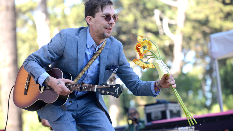 Justin Townes Earle performing holding flowers