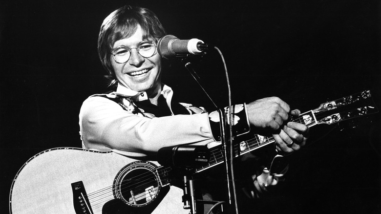 John Denver with guitar and microphone