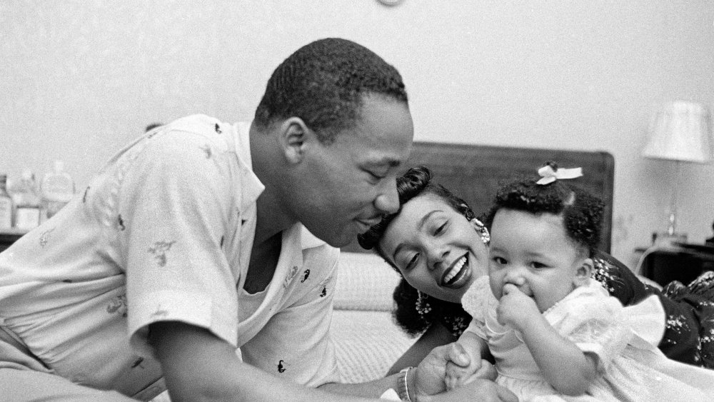 Civil rights leader Reverend Martin Luther King, Jr. relaxes at home with his wife Coretta and first child Yolanda in May 1956