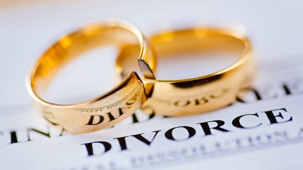 Divorce legal papers and broken wedding rings.