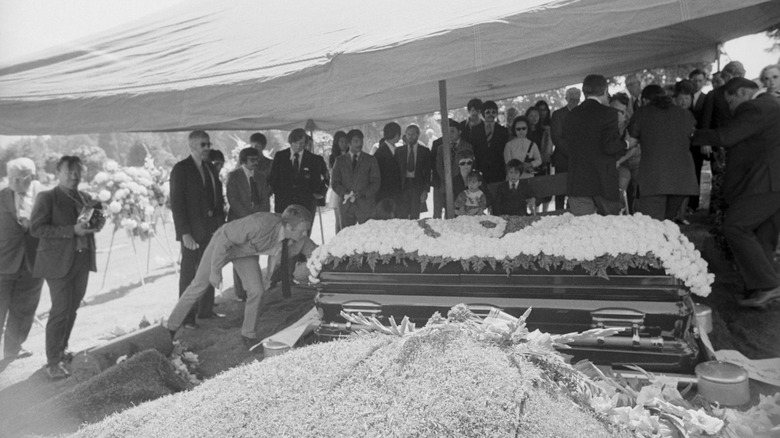 Mourners surrounding the coffin at Bruce Lee's funeral