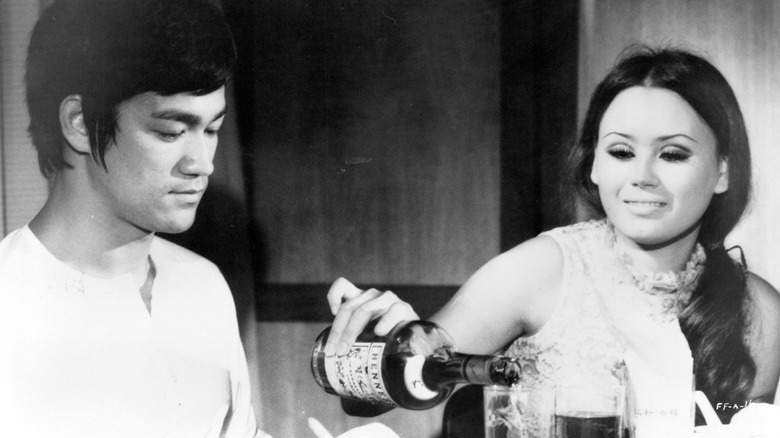 A woman pouring Bruce Lee a drink