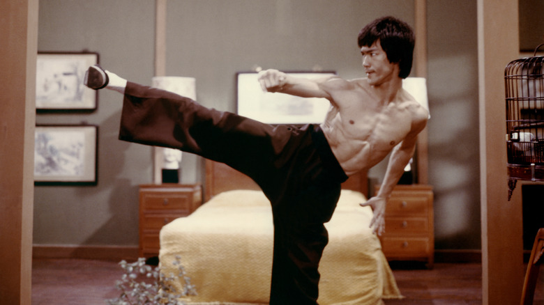 Bruce Lee doing a kick in a bedroom