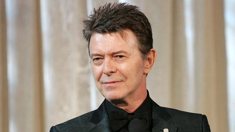 david bowie smirking onstage and looking off