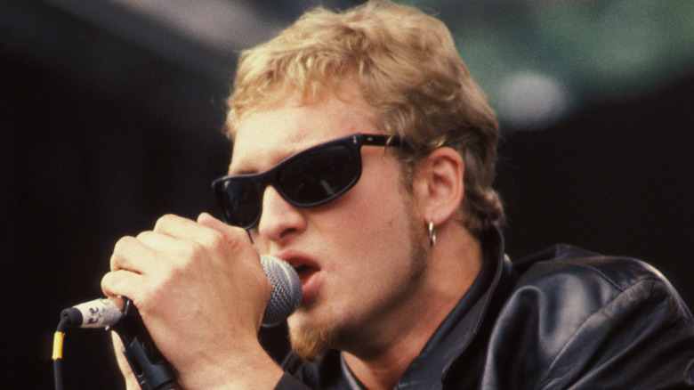 layne staley clutching microphone and singing on stage