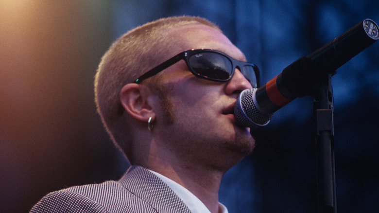 layne staley singing into microphone on stage while wearing a suit