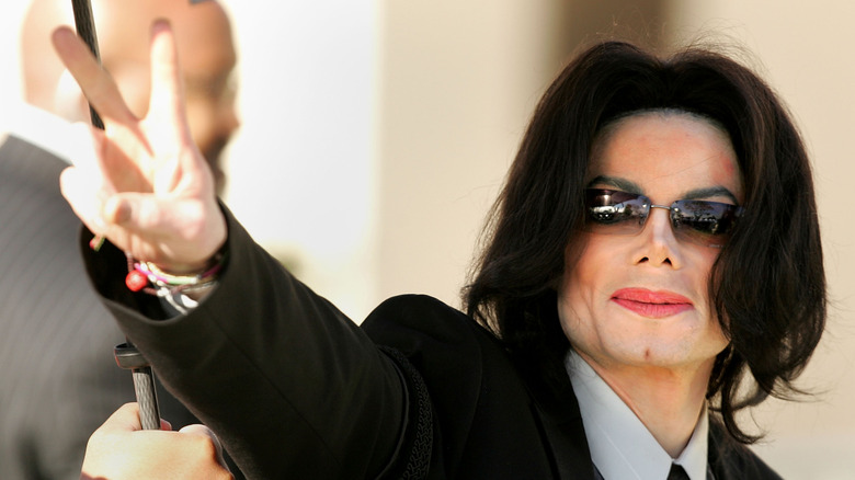 Michael Jackson in sunglasses giving peace sign