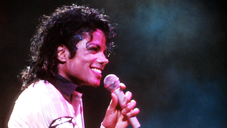 Michael Jackson smiling with microphone on stage