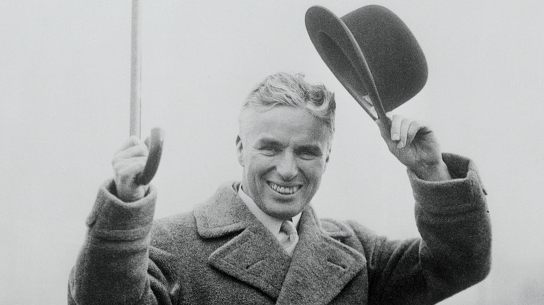 Charlie Chaplin with hat and cane raised