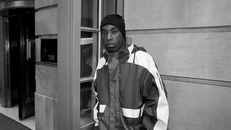 Big L by doorway in coat