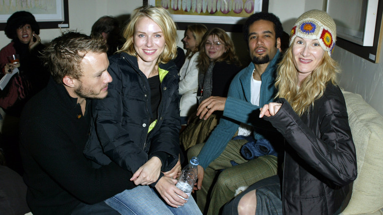 Heath Ledger and actors sitting together indoors smiling