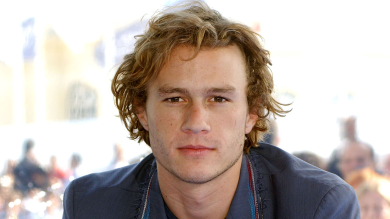 Heath Ledger curly hair blue suit outdoors neutral