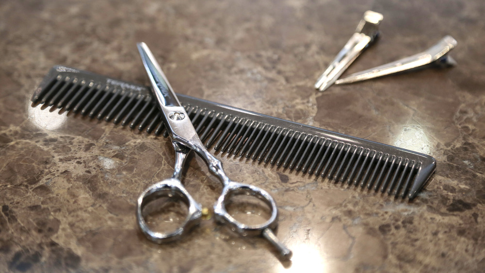 Scissors lying across a comb