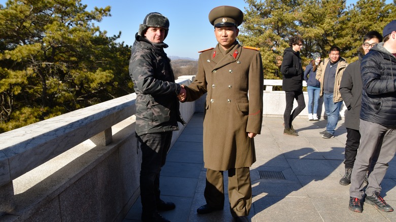 A tourist shaking hands with a North Korean soldier