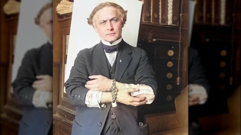 Harry Houdini with hands chained
