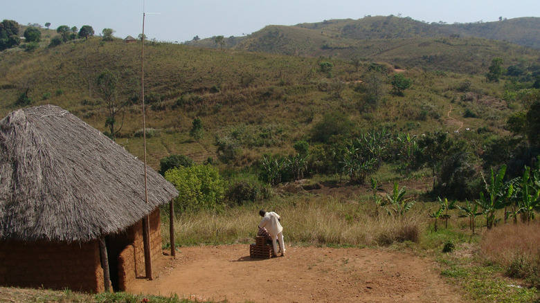 man works near mud house