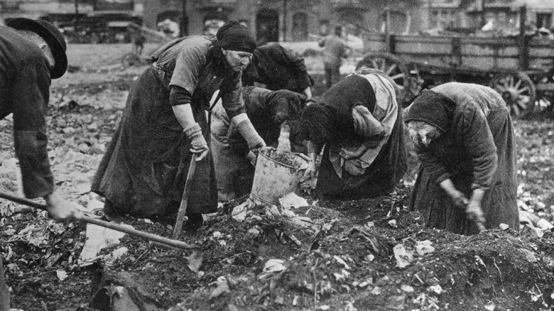 german women digging through garbage