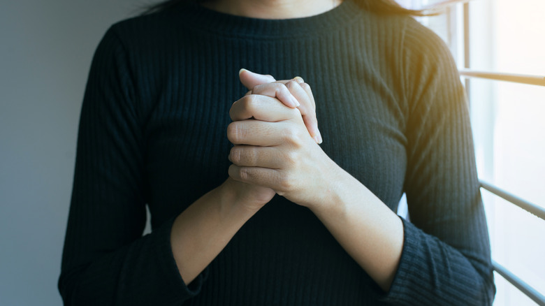 Woman holding her hands together