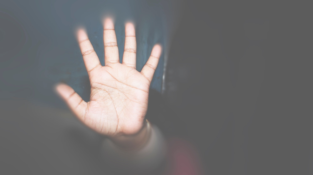 hand behind a glass