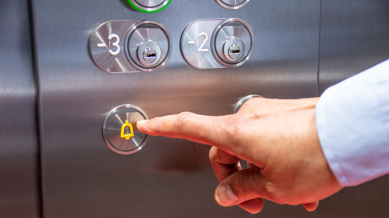 finger pressing elevator button