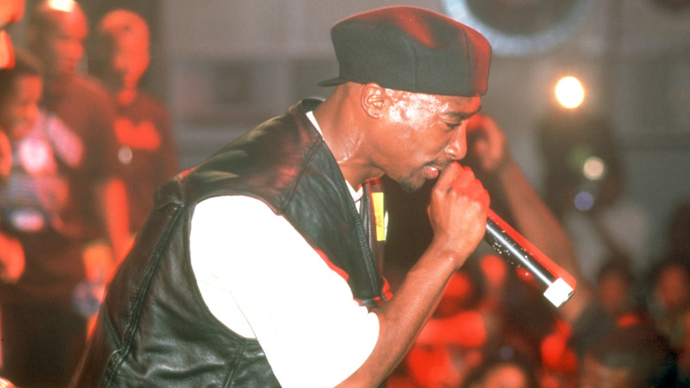 Tupac holding microphone performing