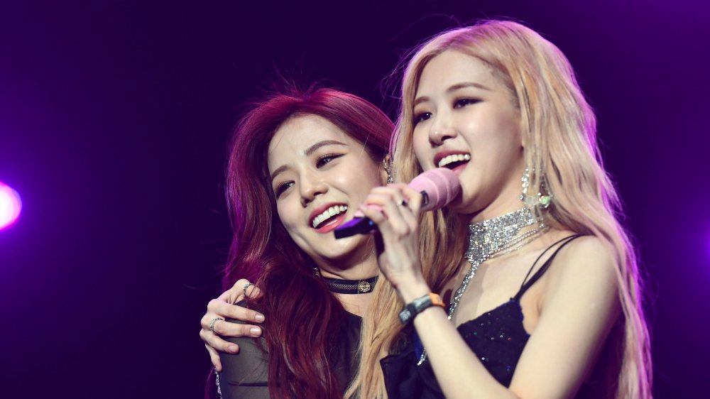 Jisoo (left) and Rosé (right) of Blackpink hug each other on stage