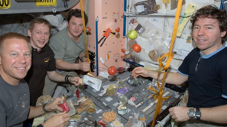 Astronauts share a meal in the International Space Station.