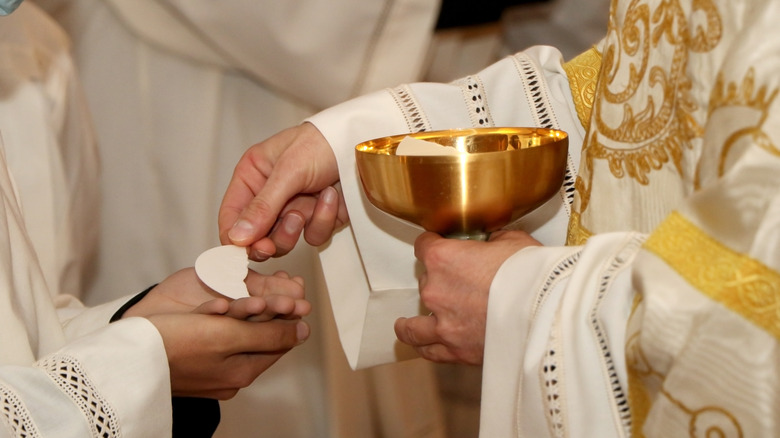 a priest giving the host