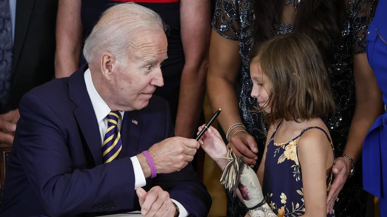 Biden hands pen to girl