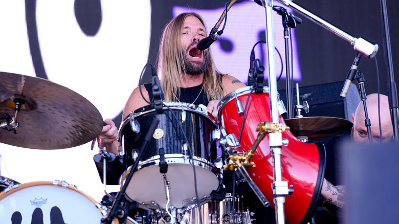 Taylor Hawkins playing the drums and singing