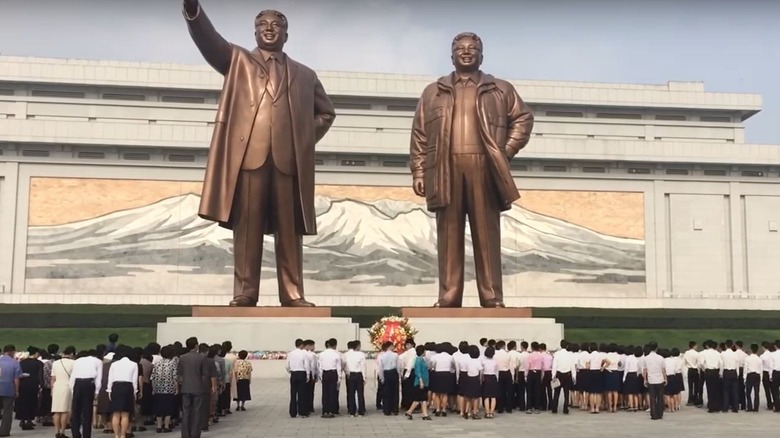 North Koreans worshipping great leader statues