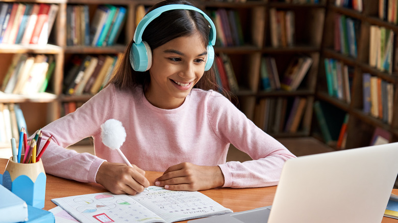 a young girl studying at her computer