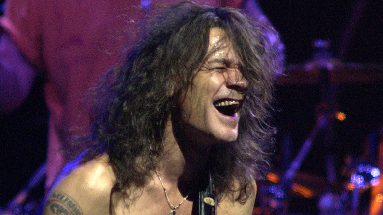 eddie van halen playing guitar shirtless with eyes closed in 2004