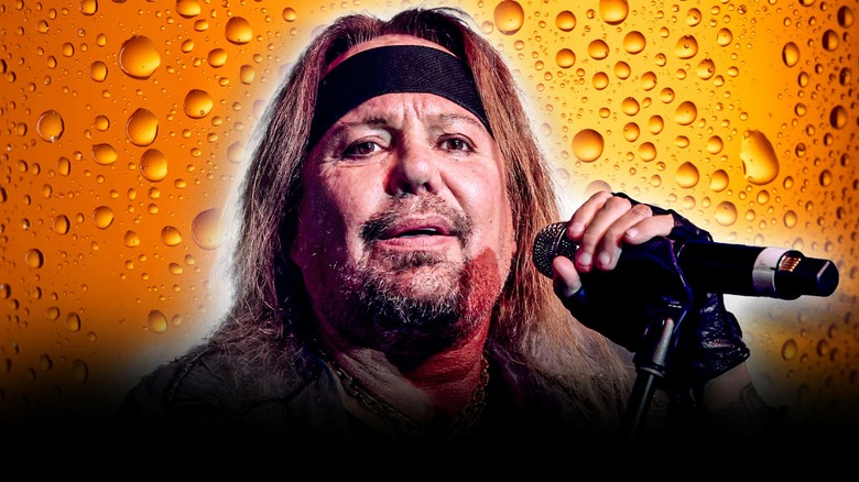 vince neil with bandanna onstage holding mic