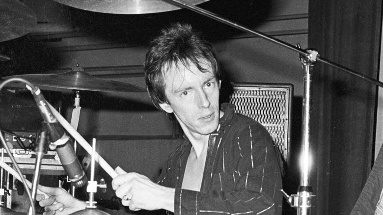 topper headon playing drums during a clash show in the 80s