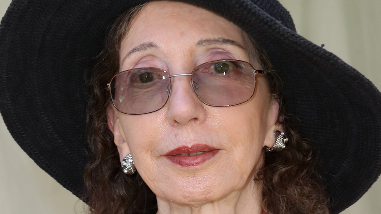 Joyce Carol Oates looks out from under her hat