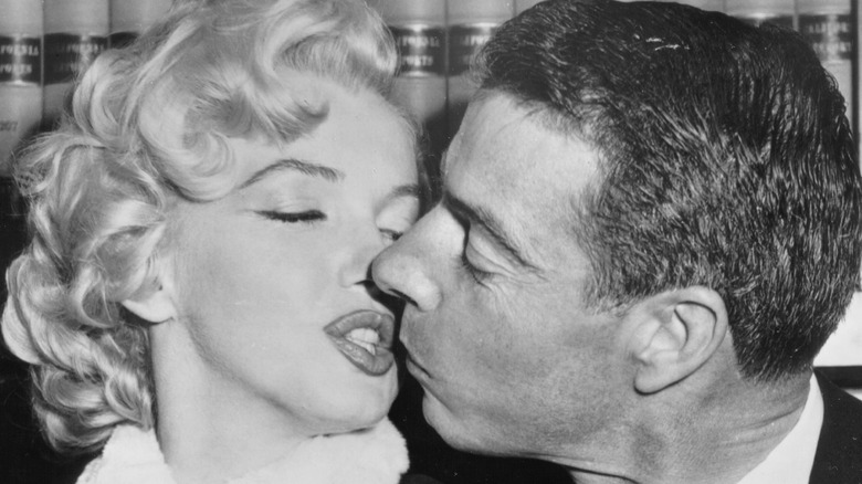 Marilyn Monroe and Joe DiMaggio share a kiss