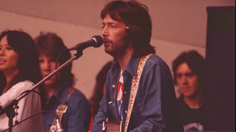 Clapton on stage guitar denim jacket singing