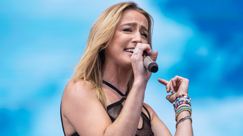 ingrid andress squinting and singing outside on stage