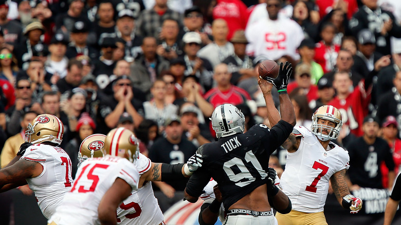 49ers player throws pass on field