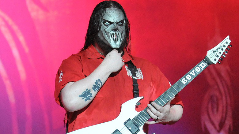 Slipknot's Mick Thomson posing on stage with his guitar in 2011