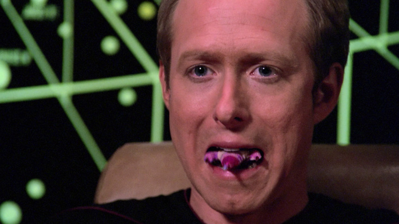 An alien escapes a man's mouth in a shot from Star Trek's "Conspiracy"