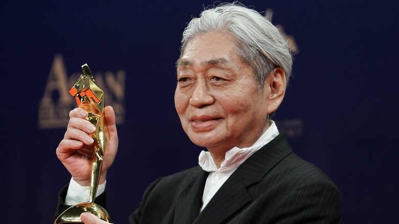 Haruomi Hosono holding an award