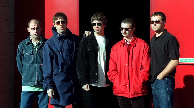Five original members of Oasis in coats