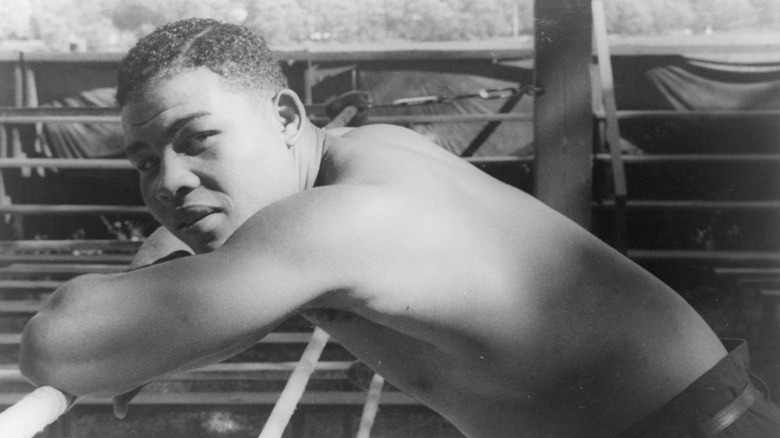 Joe louis shirtless leans against the ropes