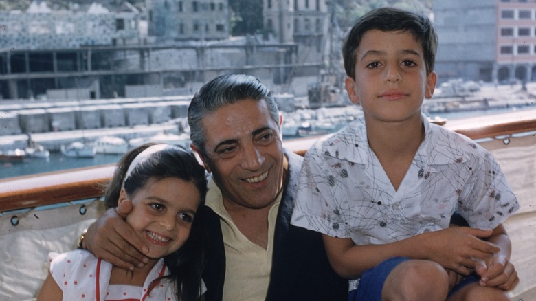 Christina Onassis smiles with her father and brother