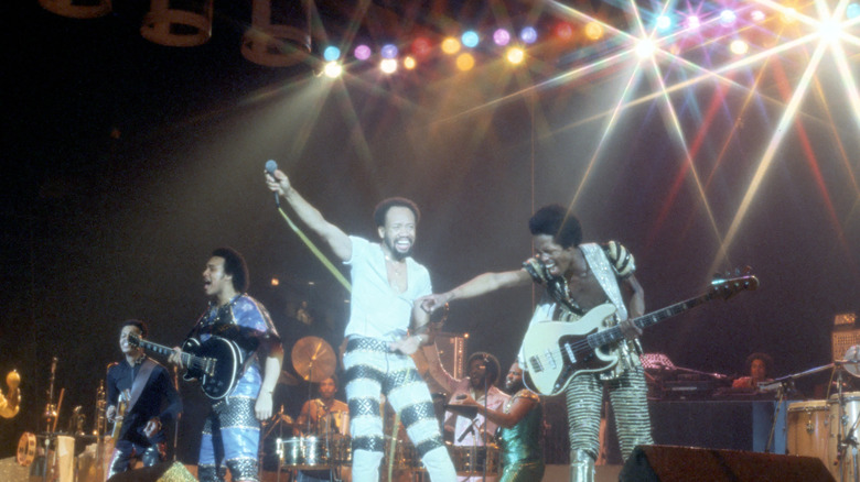 Earth, Wind & Fire onstage arms aloft studio lights