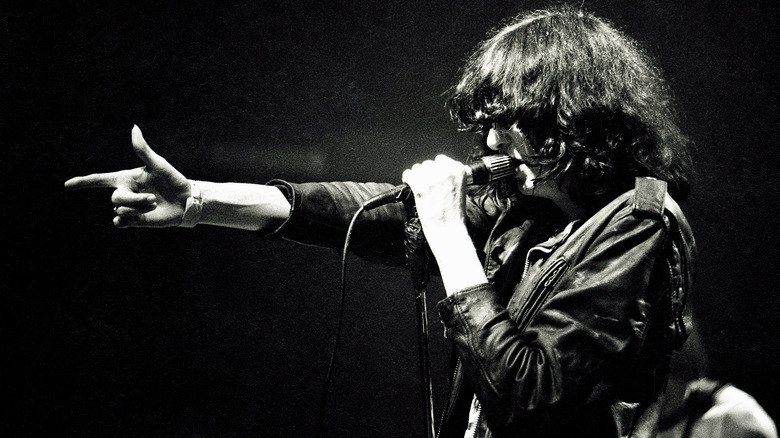 Joey Ramone performing on stage arm raised